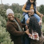 Happy black family having fun in fir tree farm