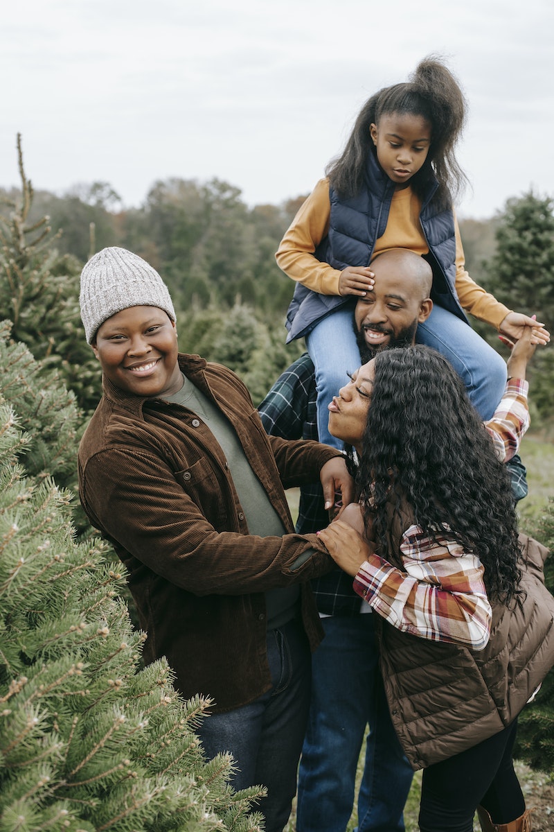 Happy black family having fun in fir tree farm